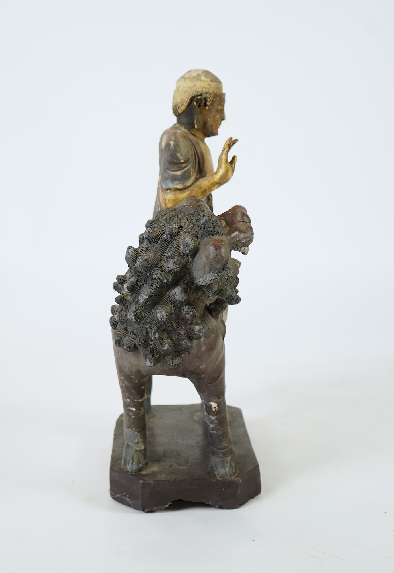 A Chinese gilt and polychrome lacquered stucco work and wood figure of Manjushri on a lion, Yuan-Ming dynasty